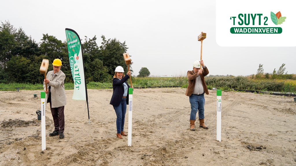 Wethouder, Woonpartners en aannemer slaan een symbolische paal in de grond van het appartementencomplex