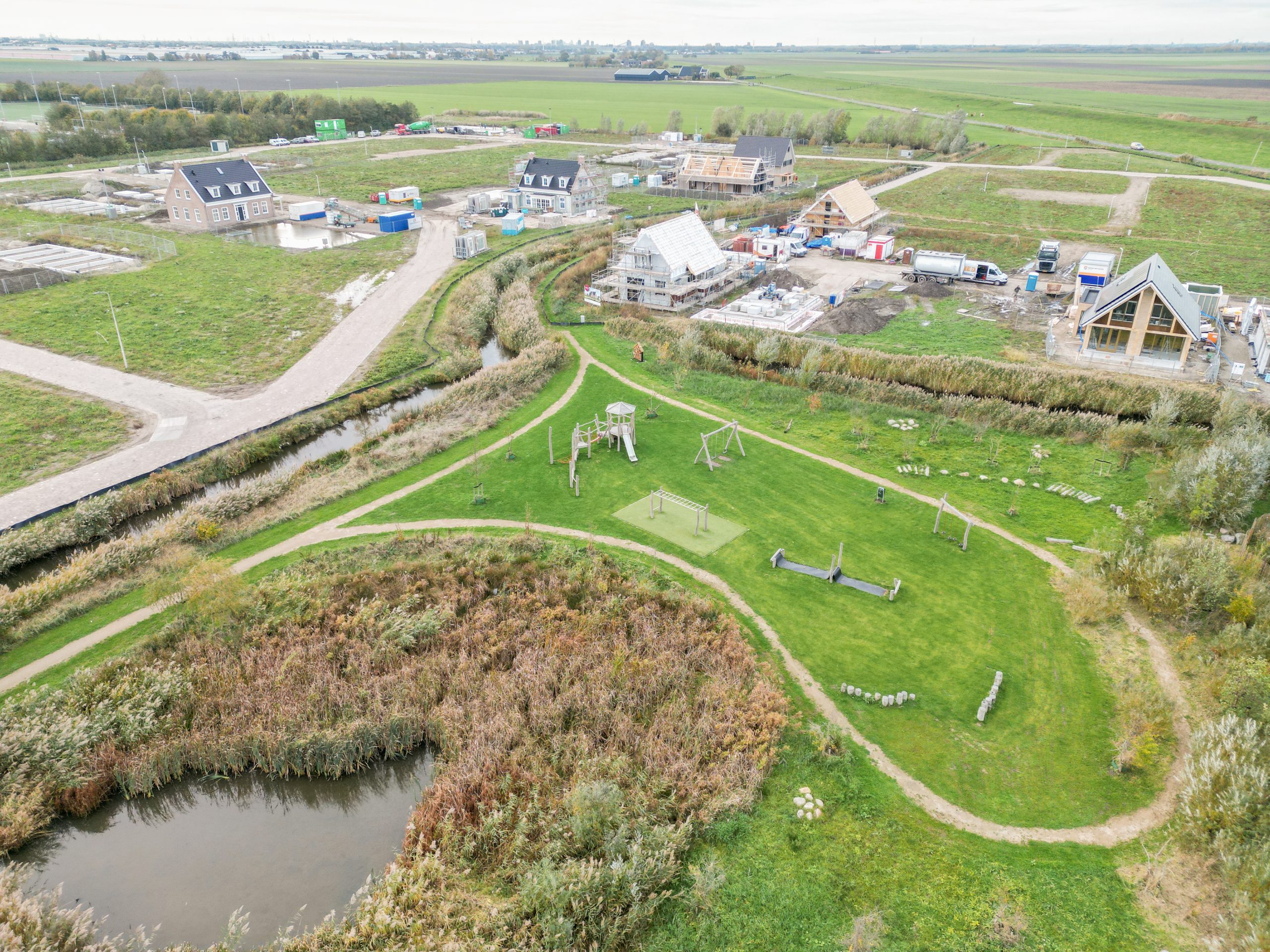 Luchtfoto van gebied ’t Suyt 2, met vooraan een plukbos en op de achtergrond woningen die nog in aanbouw zijn.